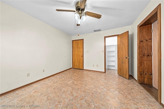 unfurnished bedroom with ceiling fan and a textured ceiling