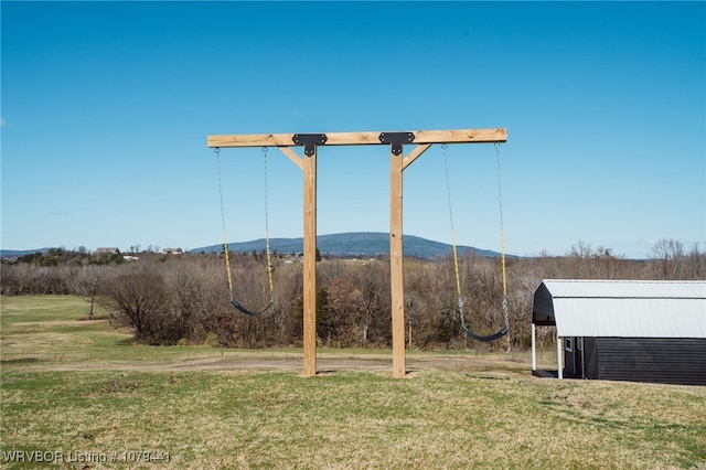 view of yard featuring a mountain view, an outbuilding, and an outdoor structure