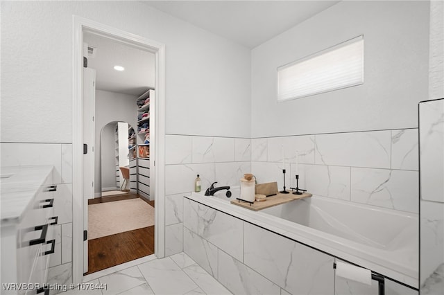 kitchen with arched walkways, visible vents, white cabinets, marble finish floor, and light countertops