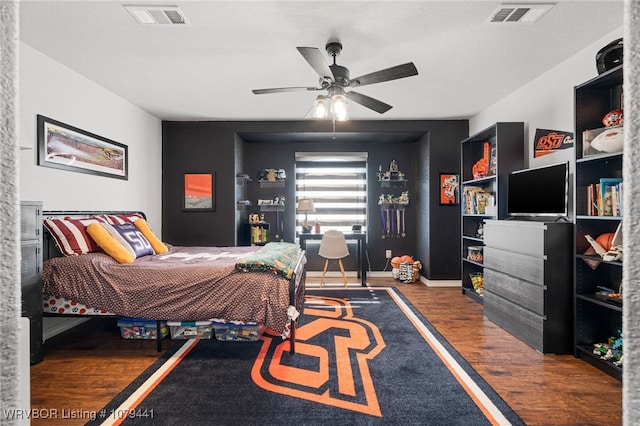 bedroom with baseboards, wood finished floors, visible vents, and a ceiling fan