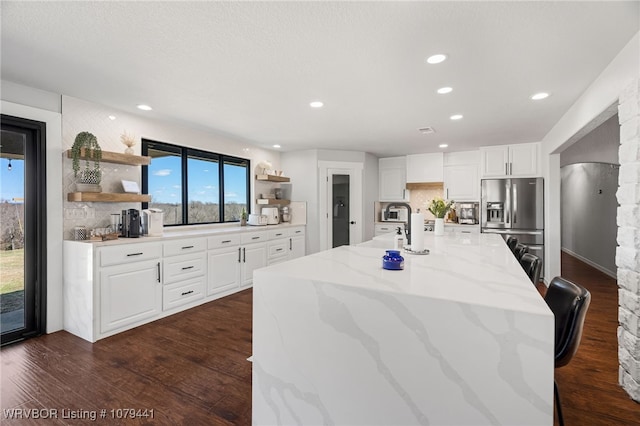 21580 Ranch Rd, Howe, OK 74940 - kitchen with open shelves, stainless steel fridge, backsplash, white cabinetry, and recessed lighting