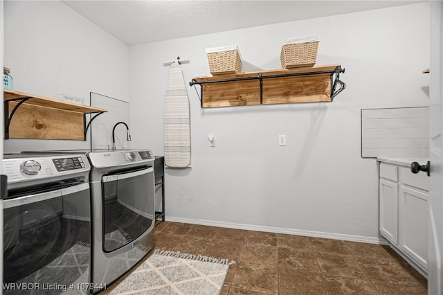 laundry area with cabinet space, baseboards, and washer and clothes dryer