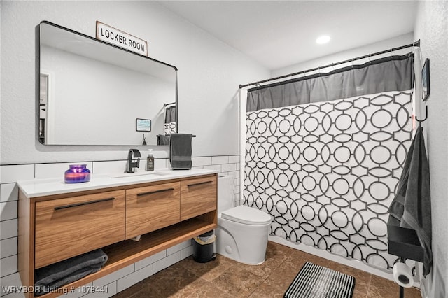 full bathroom featuring a wainscoted wall, tile walls, a shower with shower curtain, toilet, and vanity