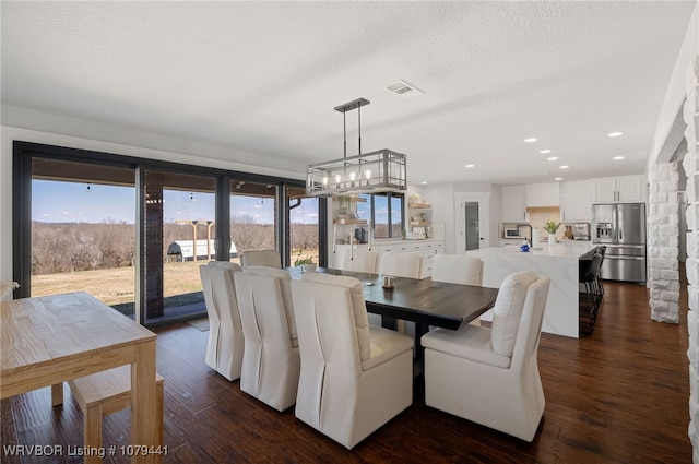 dining area with visible vents, dark wood finished floors, a textured ceiling, a chandelier, and recessed lighting