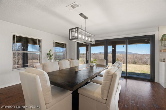 21580 Ranch Rd, Howe, OK 74940 - dining room with dark wood finished floors, a mountain view, baseboards, and a chandelier