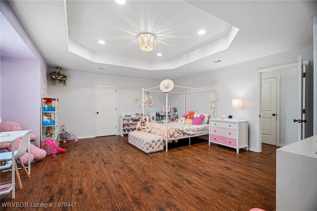 bedroom with baseboards, a tray ceiling, wood finished floors, and recessed lighting