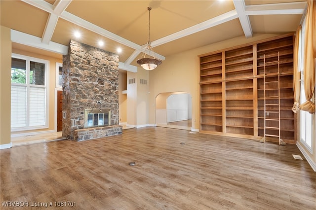 1808 Bramble Brae St, Fort Smith, AR 72908 - unfurnished living room featuring beamed ceiling, wood finished floors, a stone fireplace, coffered ceiling, and arched walkways