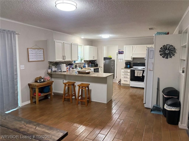 309 N 25th St, Ozark, AR 72949 - kitchen with white appliances, a peninsula, a textured ceiling, dark wood-type flooring, and ornamental molding