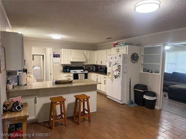 309 N 25th St, Ozark, AR 72949 - kitchen with white fridge with ice dispenser, range with electric stovetop, washer / dryer, a textured ceiling, and a peninsula