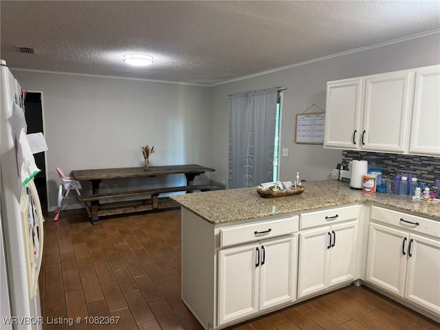 309 N 25th St, Ozark, AR 72949 - kitchen featuring dark wood finished floors, a peninsula, white cabinets, crown molding, and a textured ceiling
