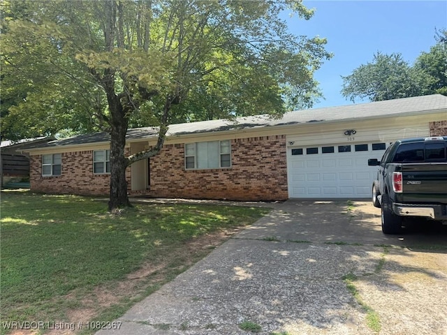 309 N 25th St, Ozark, AR 72949 - view of front of home with concrete driveway, a front yard, an attached garage, and brick siding