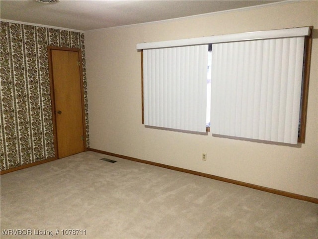 carpeted spare room with ornamental molding