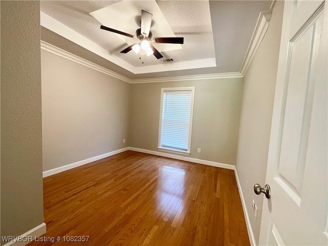 4104 Glen Flora Way, Fort Smith, AR 72908 - empty room featuring a tray ceiling, wood finished floors, a textured ceiling, a ceiling fan, and crown molding