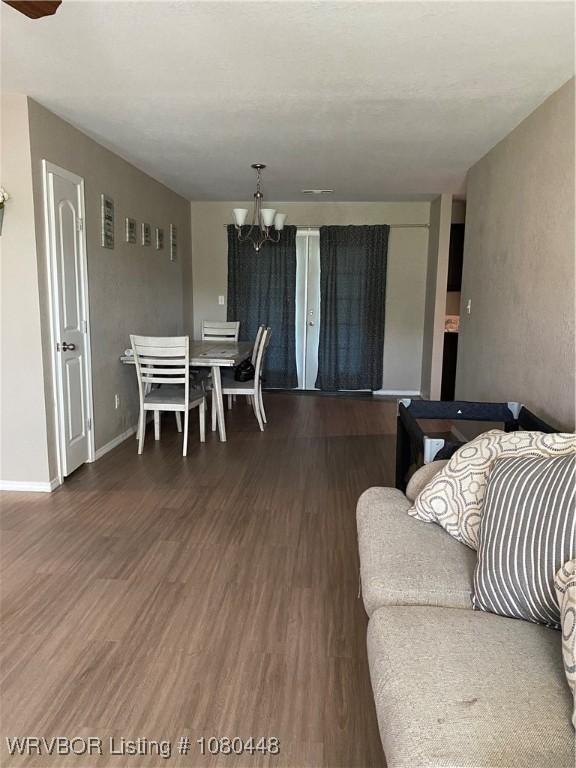 1111 Bluebird Dr, Cedarville, AR 72932 - living room featuring baseboards, wood finished floors, and a chandelier