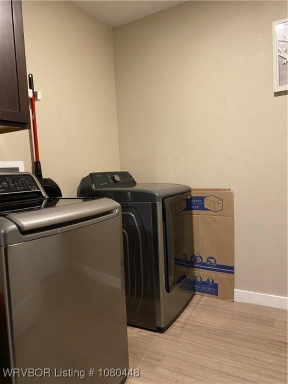 1111 Bluebird Dr, Cedarville, AR 72932 - laundry area with cabinet space, light wood-type flooring, baseboards, and washer and dryer
