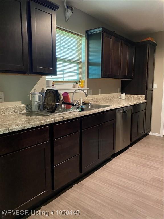 1111 Bluebird Dr, Cedarville, AR 72932 - kitchen with dark brown cabinets, a sink, dishwasher, light wood finished floors, and light stone countertops