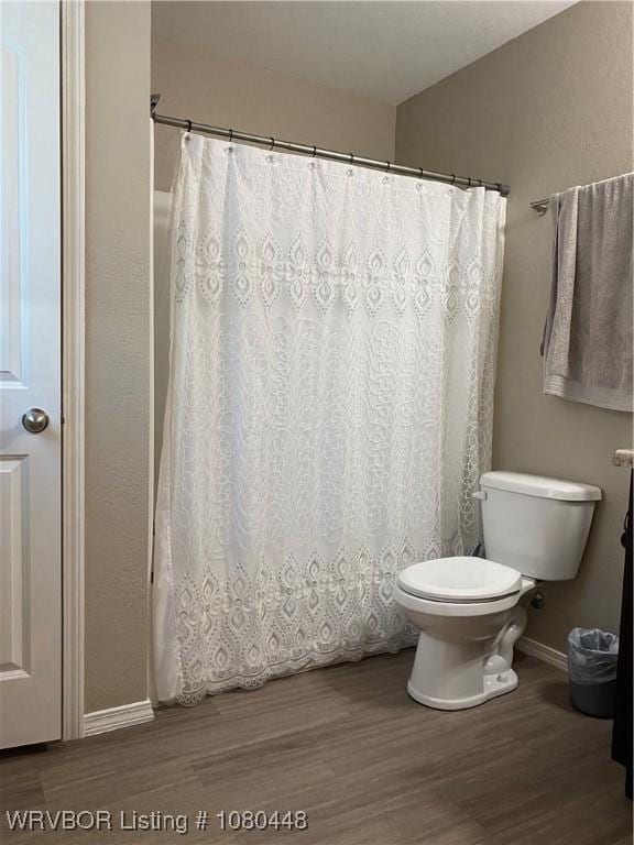 1111 Bluebird Dr, Cedarville, AR 72932 - full bathroom featuring baseboards, toilet, wood finished floors, and curtained shower
