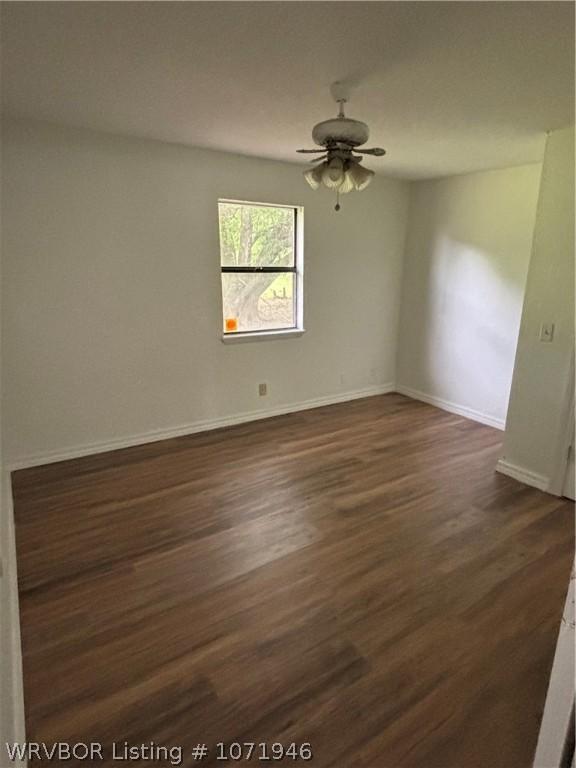 unfurnished room with ceiling fan and dark wood-type flooring