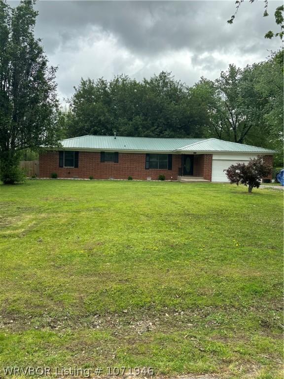 view of front of home with a front yard and a garage