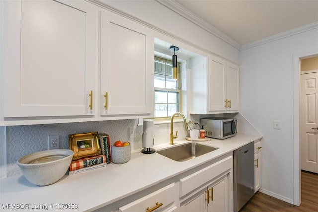 kitchen featuring light countertops, ornamental molding, appliances with stainless steel finishes, white cabinets, and a sink