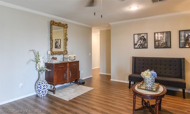 sitting room featuring dark wood-style floors, baseboards, a ceiling fan, and ornamental molding