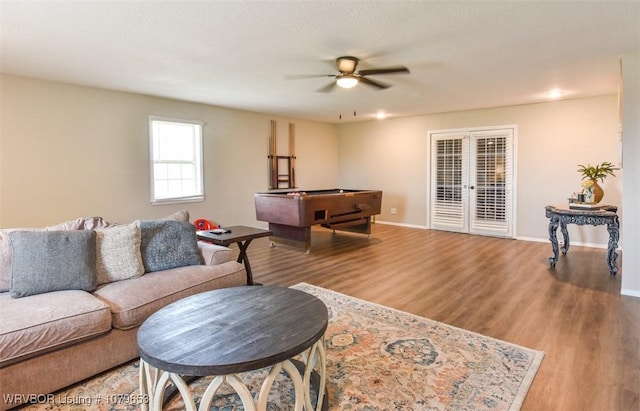 living area with wood finished floors, baseboards, french doors, and ceiling fan