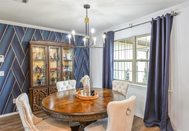 dining area with a notable chandelier, wood finished floors, baseboards, and ornamental molding