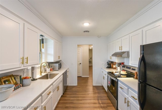 kitchen featuring visible vents, a sink, light countertops, under cabinet range hood, and appliances with stainless steel finishes