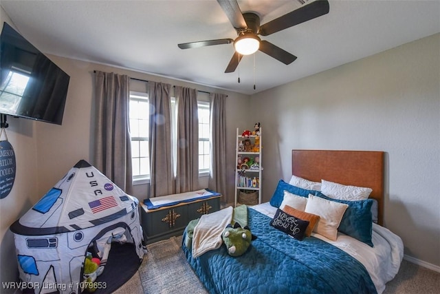 carpeted bedroom featuring baseboards and ceiling fan