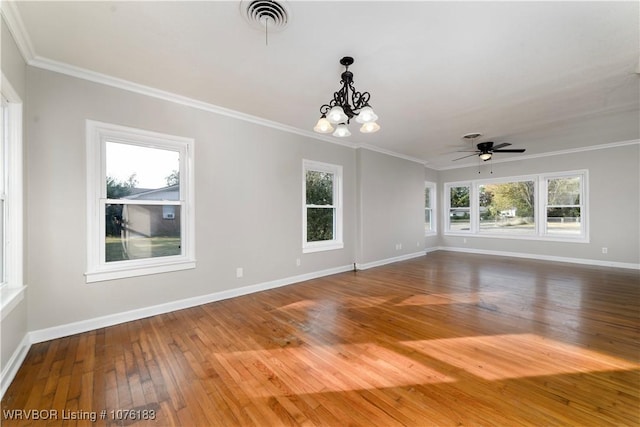 unfurnished room featuring wood-type flooring, ceiling fan with notable chandelier, ornamental molding, and a healthy amount of sunlight