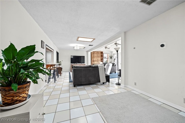 8437 Sebastian Lake Dr, Hackett, AR 72937 - living area featuring light tile patterned flooring, a textured ceiling, a healthy amount of sunlight, and visible vents