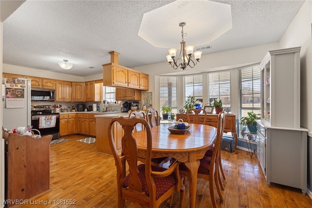 2027 High Meadow Ln, Alma, AR 72921 - dining space with a textured ceiling, light wood-style flooring, and a chandelier