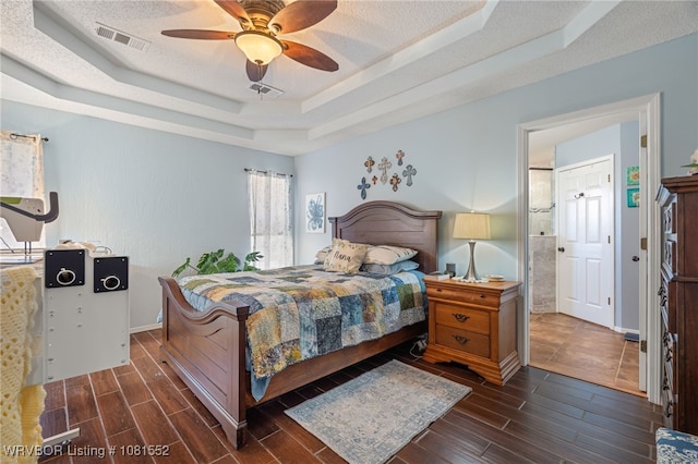 2027 High Meadow Ln, Alma, AR 72921 - bedroom featuring a tray ceiling, dark wood-type flooring, a textured ceiling, and ceiling fan