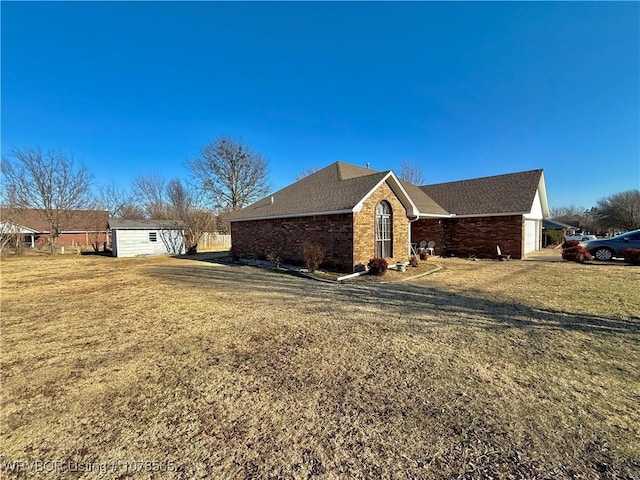 view of property exterior with a storage unit and a lawn