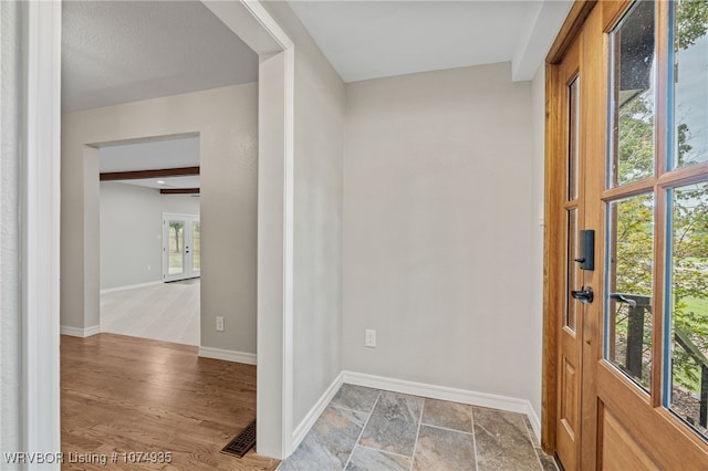 foyer featuring beam ceiling