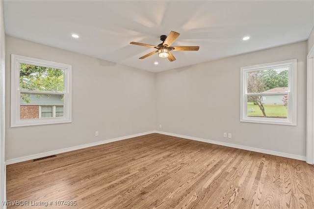 spare room featuring light hardwood / wood-style flooring, a wealth of natural light, and ceiling fan