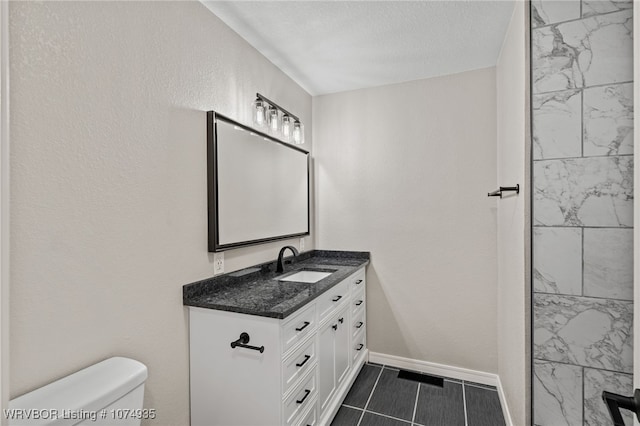 bathroom with vanity, a textured ceiling, and toilet