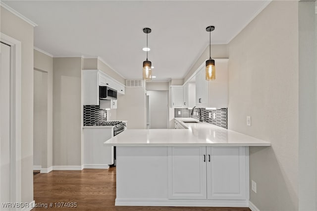 kitchen featuring kitchen peninsula, decorative backsplash, sink, white cabinets, and stainless steel range with gas stovetop