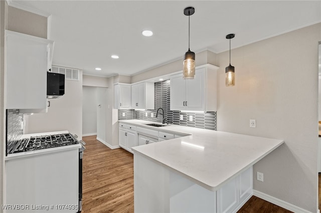 kitchen featuring white cabinets, sink, decorative backsplash, white gas range, and kitchen peninsula