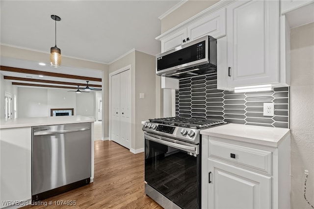 kitchen featuring tasteful backsplash, beamed ceiling, white cabinets, and appliances with stainless steel finishes