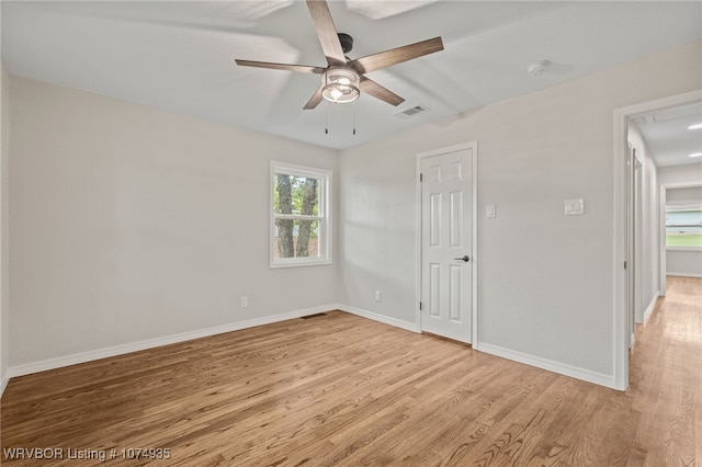 spare room featuring plenty of natural light, ceiling fan, and light wood-type flooring