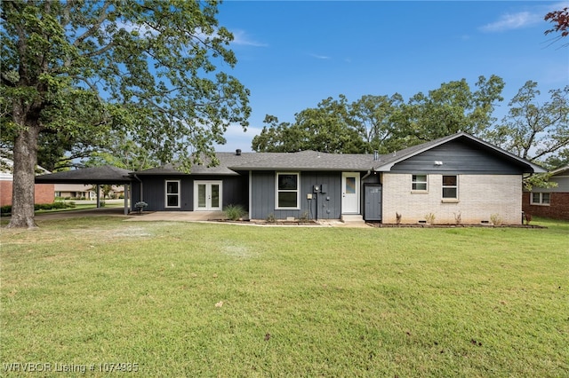 view of front of house with french doors, a front yard, and a carport