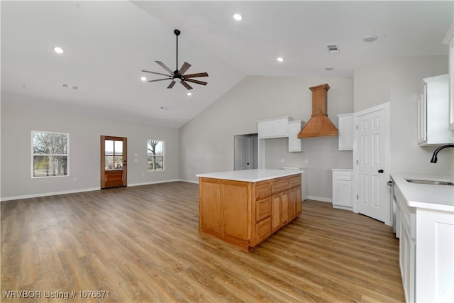 kitchen featuring a center island, sink, ceiling fan, light hardwood / wood-style floors, and white cabinetry