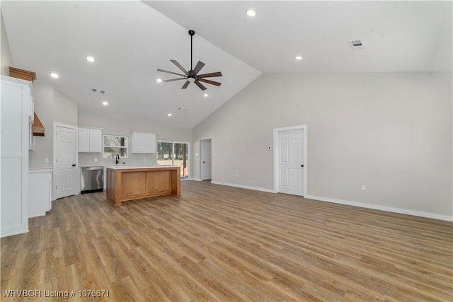 kitchen with a center island, high vaulted ceiling, white cabinets, stainless steel dishwasher, and ceiling fan