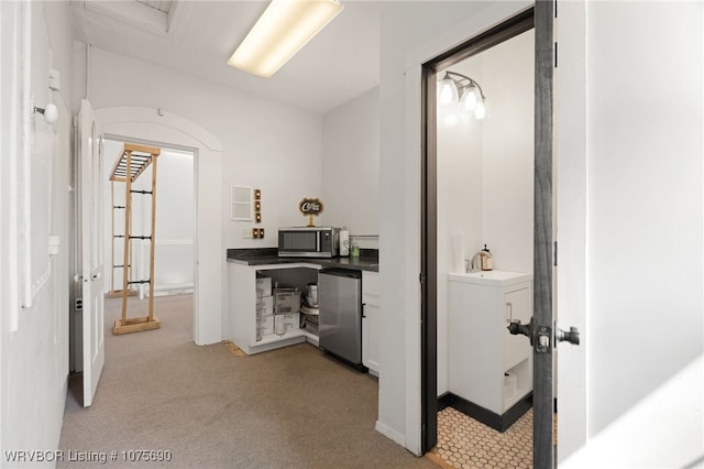 corridor with light colored carpet and sink