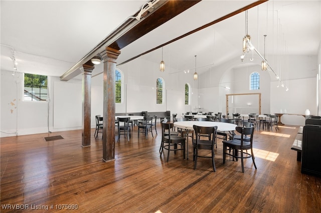 dining area with high vaulted ceiling and hardwood / wood-style flooring