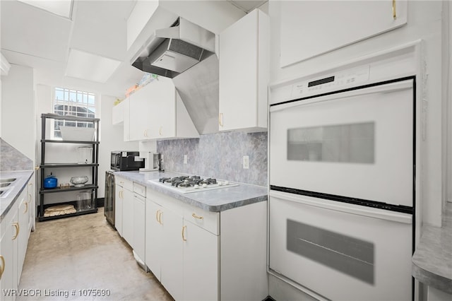 kitchen with ventilation hood, decorative backsplash, white appliances, and white cabinetry