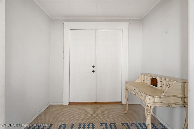 carpeted entryway featuring ornamental molding