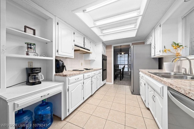 kitchen featuring appliances with stainless steel finishes, white cabinets, light tile patterned flooring, a sink, and under cabinet range hood