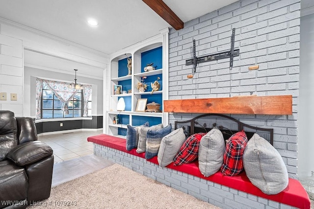 living area with built in features, ornamental molding, a brick fireplace, tile patterned flooring, and beamed ceiling